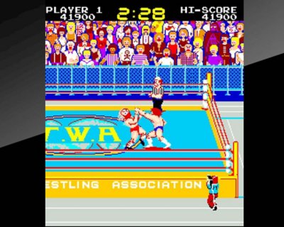 Captura de pantalla del juego Mat Mania con dos luchadores peleando en un ring.