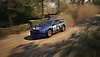 EA Sports WRC 스크린샷, 숲 코스에서 자욱한 먼지를 일으키는 1997 Subaru Impreza WRC