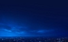 Background artwork of a night sky with the night lights of a city below