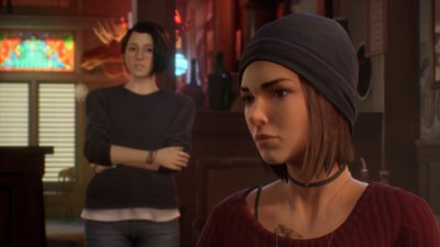 Life Is Strange True Colors - Capture d’écran d’Alex en arrière-plan qui dialogue avec un autre personnage