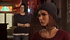 Life Is Strange True Colors-skærmbillede, der viser Alex i snak med en anden figur i baggrunden