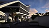 Captura de tela de XDefiant mostrando um edifício moderno com vários ângulos de concreto e janelas.