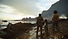 A Plague Tale: Requiem; captura de pantalla que muestra a Amicia y Hugo de pie en la costa, mirando un castillo a la distancia