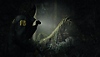 《Alan Wake 2》螢幕截圖，呈現薩佳·安德森在森林裡用手電筒照亮掛在樹枝上的神秘三角形符號