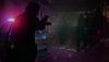 《Alan Wake 2》螢幕截圖，呈現艾倫拿著槍並照亮幾個朦朧的人影