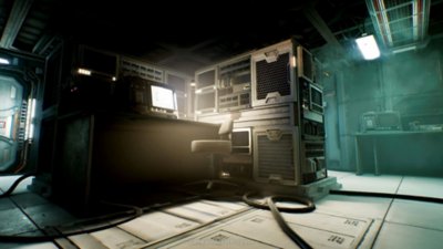 Alien: Rogue Incursion screenshot showing a desk with a monitor on it with a tower and two lights at either end of the room