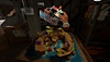 Captura de pantalla de Another Fisherman's Tale con una maqueta de isla sobre una mesa y una mano que sostiene un barco en miniatura