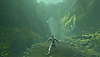 Istantanea della schermata di Baby Steps che ritrae il protagonista mentre si prepara a fare un lungo passo in un ambiente pieno di verde lussureggiante