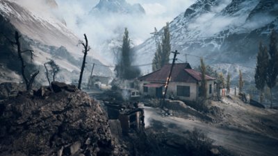A small village lies in ruins, set against a snowy mountain range.
