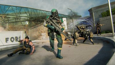 Three operators and a quadruped robot working together in the midst of a firefight.