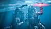 Captura de pantalla de Call of Duty: Modern Warfare III que muestra a dos operadores con equipo de buceo plantando una carga explosiva debajo de una capa de hielo