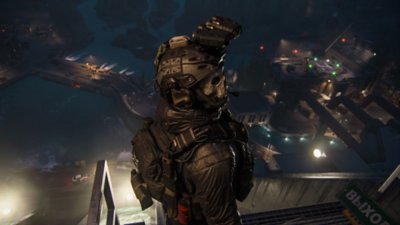 ภาพหน้าจอ Call of Duty: Modern Warfare III แสดงให้เห็น Ghost ยืนอยู่ด้านบนสิ่งก่อสร้างอุตสาหกรรมขนาดใหญ่โดยแต่งชุดกลยุทธ์