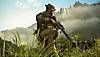 Istantanea della schermata di Call of Duty Modern Warfare III che rappresenta un membro della Task Force 141 accucciato nell’erba alta su uno sfondo di montagne