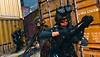 Call of Duty: Warzone 2.0 ekran görüntüsü, etrafında nakliye konteynerleri bulunan taktiksel ekipmanlar kuşanmış karakterleri gösteriyor
