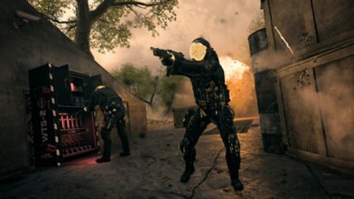 Call of Duty: Warzone – Screenshot, der einen Charakter zeigt, der mit seiner Waffe zielt, während ein anderer ein Waffenlager durchstöbert
