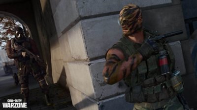 Başka bir oyuncu köşeden yaklaşırken duvara yaslanmış bir Operatörü gösteren Call of Duty Warzone ekran görüntüsü