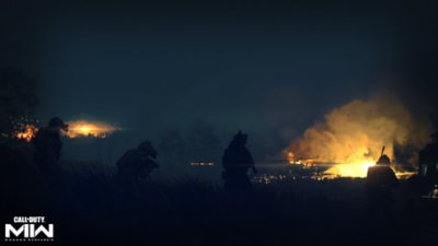 《決勝時刻：現代戰爭II 2022》螢幕截圖，顯示在一片漆黑場景中遠處的火焰