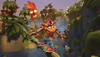 لقطة شاشة من لعبة Crash Bandicoot 4: it's About Time تصوّر شخصية crash يتزحلق ممسكًا بجزع شجرة عبر الأدغال.