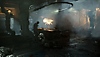 Snímek obrazovky ze hry Dead Space, na kterém Isaac stojí nad velkým stolem.