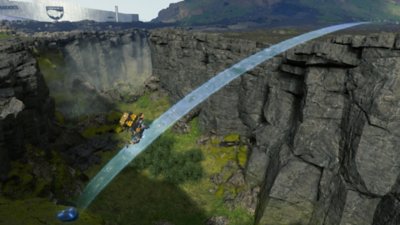 Screenshot zu Death Stranding Director's Cut, der Sam zeigt, wie er eine von Spielern erstellte Brücke benutzt.