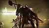 Destiny 2 – snímek obrazovky zobrazující velkého nepřítele se zbraní podobnou sekeře