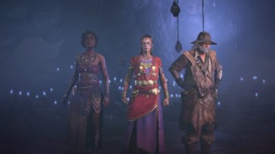 Diablo IV Season 7 screenshot showing a trio of witch characters standing in a cave