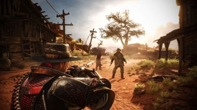 Captura de pantalla de Evil West que muestra a un vaquero en un pequeño pueblo desierto que les apunta a los enemigos, con un árbol de fondo