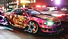 Need for Speed Unbound -kuvakaappaus, jossa vaaleanpunaisen, mustan ja keltaisen sävyisen auton renkaiden päällä näkyy neonvärisiä tähtikuvioita