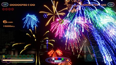 Captura de pantalla de Fantavision 202X que muestra un gran espectáculo de fuegos artificiales con la ciudad de fondo