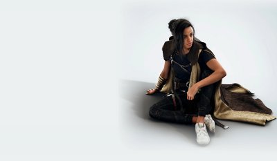 Forspoken artwork showing Frey sitting on the floor with Cuff wrapped around her arm