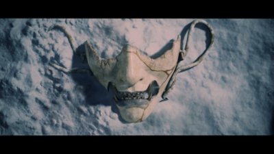 Cinematic screenshot from Ghost of Yōtei depicting a warrior's mask laid in the snow.
