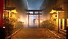 Captura de ecrã do Ghostwire: Tokyo com uma figura distante a segurar um guarda-chuva enquanto caminha por portões torii