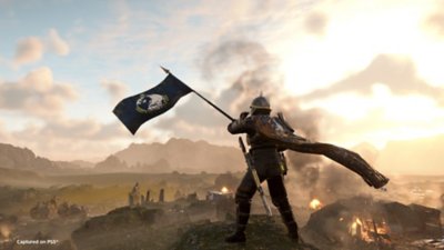 Helldivers 2 screenshot showing a Helldiver raising a flag