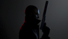 Hitman 3 – ілюстрація із зображенням головного героя Агента 47 у профіль із пістолетом з глушником.