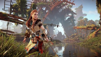 Horizon Zero Dawn Remastered screenshot showing Aloy holding a bow in front of decaying metal structures