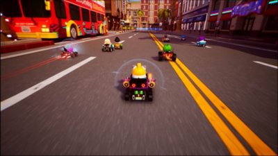Captura de pantalla de KartRider: Drift que muestra ocho karts corriendo por una ciudad mientras pasa un autobús de turistas.