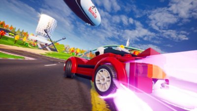 لقطة شاشة من لعبة Lego 2K Drive تعرض سيارة سباق تزيد سرعتها وتنعطف سريعًا بعيدًا عبر الأسفلت