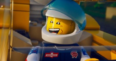 Снимок экрана из LEGO 2K Drive, на котором изображена смеющаяся мини-фигурка, изображающая гонщика.