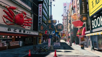 Like a Dragon Gaiden: The Man Who Erased His Name στιγμιότυπο που απεικονίζει έναν δρόμο γεμάτο καταστήματα και εστιατόρια