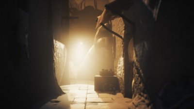 Ein Screenshot aus Little Nightmares III, der Low und Alone zeigt, wie sie sich vor einer riesigen Hand verstecken