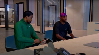 NBA 2K25 screenshot showing 2 people sitting in an office in the MyCAREER mode