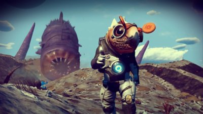 No Man's Sky screenshot showing an alien character front and centre and a sand worm in the back