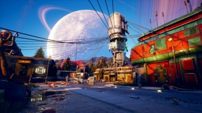 Captura de pantalla de The Outer Worlds en la que se ve un paisaje urbano con una gran torre, situado frente a un cielo ocupado por un enorme planeta