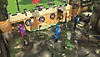 PowerWash Simulator-screenshot van drie spelers die een minigolfbaan met kasteelthema reinigen