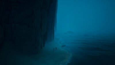 Captura de pantalla de Reanimal que muestra a los hermanos en una playa debajo de un acantilado que se cierne sobre ellos