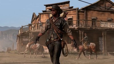 Red Dead Redemption screenshot showing John Marston walking through a town with a saloon behind him