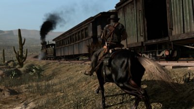 Red Dead Redemption screenshot showing John Marston on a horse beside a steam train