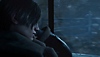 Resident Evil 4 – snímka obrazovky s Leonom, ktorý sa pozerá z okna auta