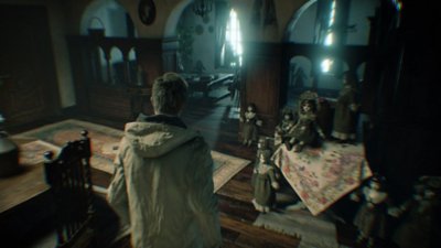 Resident Evil Village screenshot showing a third-person view of Ethan Winters in a room with dolls