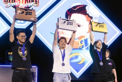 EVO 2024の写真 銅、銀、金のEVOジョイスティックを高々と掲げる3人のプレイヤー。
